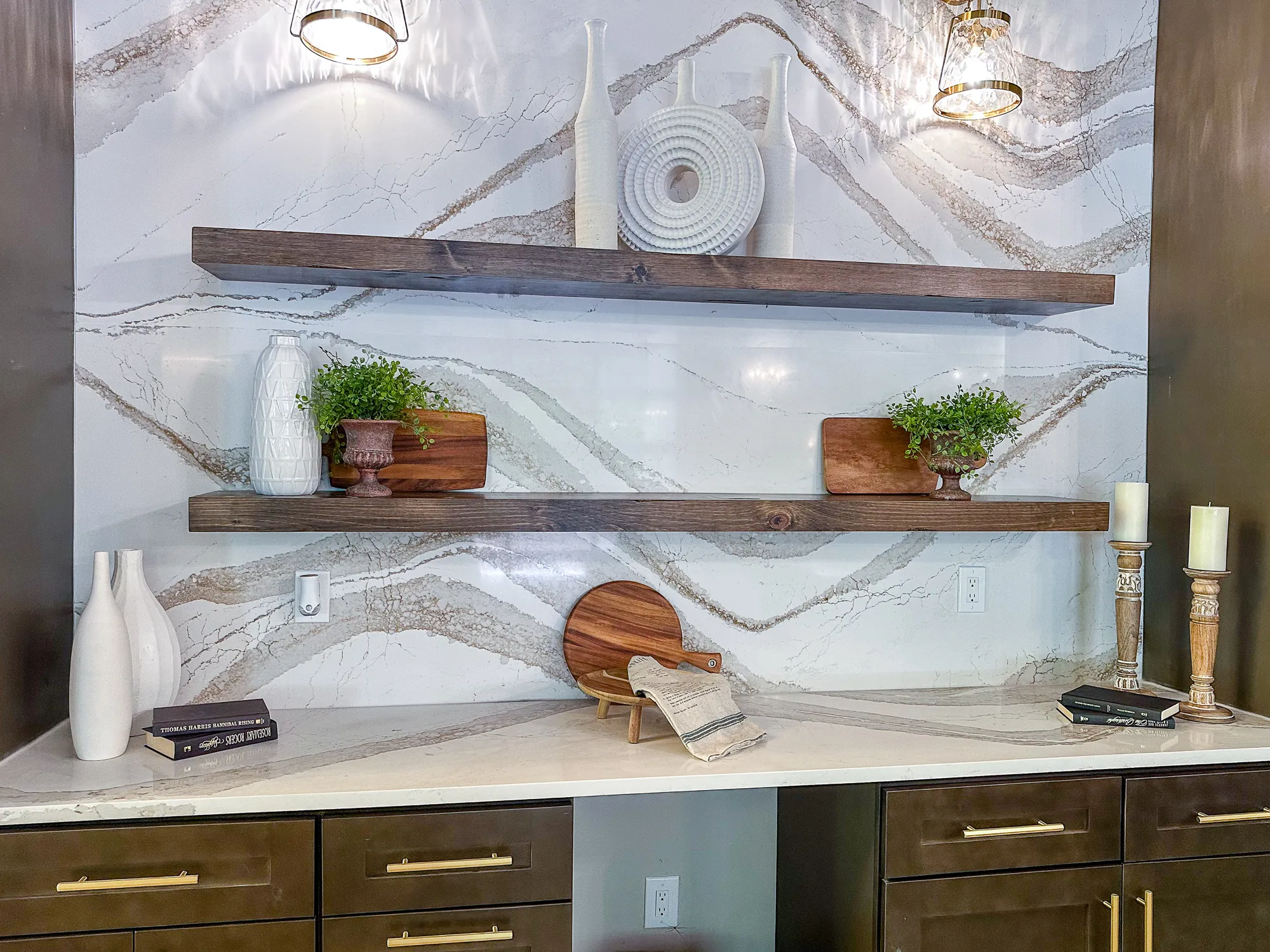 Open shelves with vases and greenery on a marble backsplash