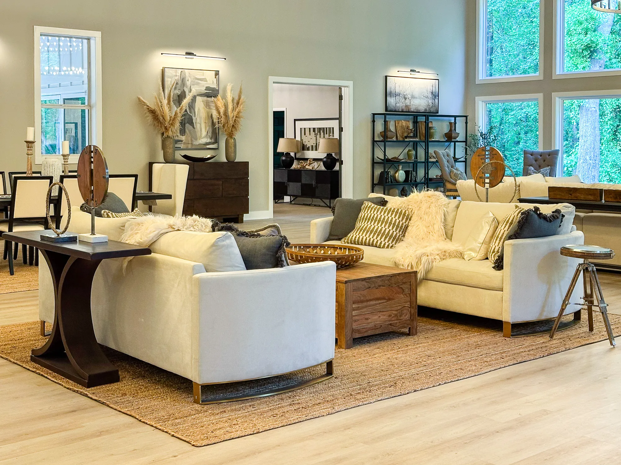 A living room with cream sofas, a wood coffee table, and tall windows