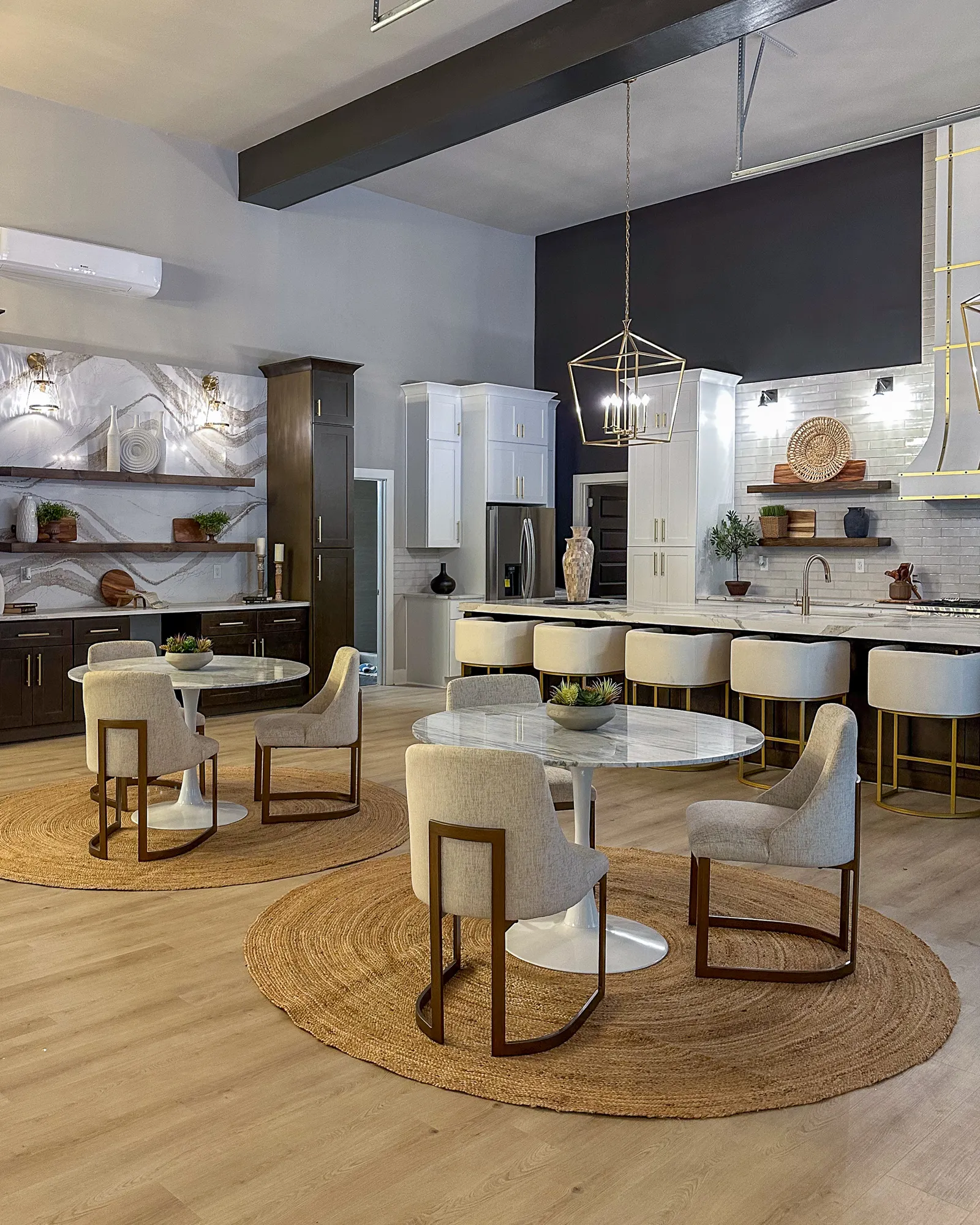 An open kitchen and dining room with round marble tables and a kitchen island